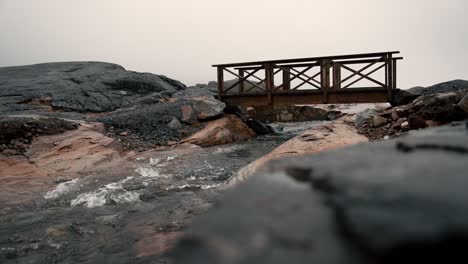 Pequeño-Puente-De-Madera-Sobre-El-Agua-Que-Fluye,-En-La-Montaña-&quot;lille-Malene&quot;-En-Nuuk