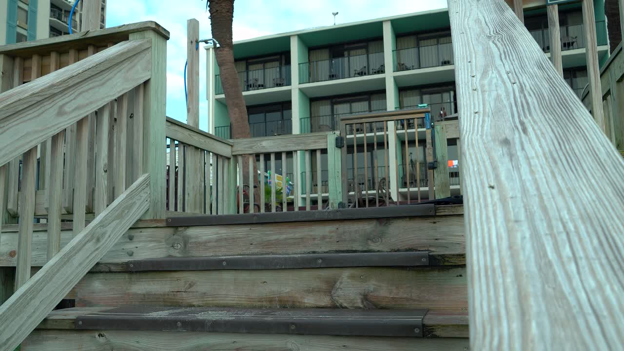 una mujer con tatuaje en el muslo sube descalza las escaleras