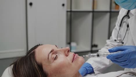 Woman receiving lip filler injection