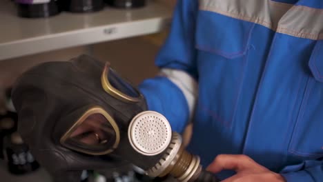 trabajador inspeccionando y manejando una máscara de gas