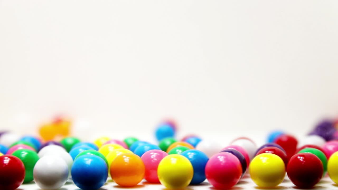 cámara lenta inversa de chicles rebotando y cayendo fuera del marco hacia atrás