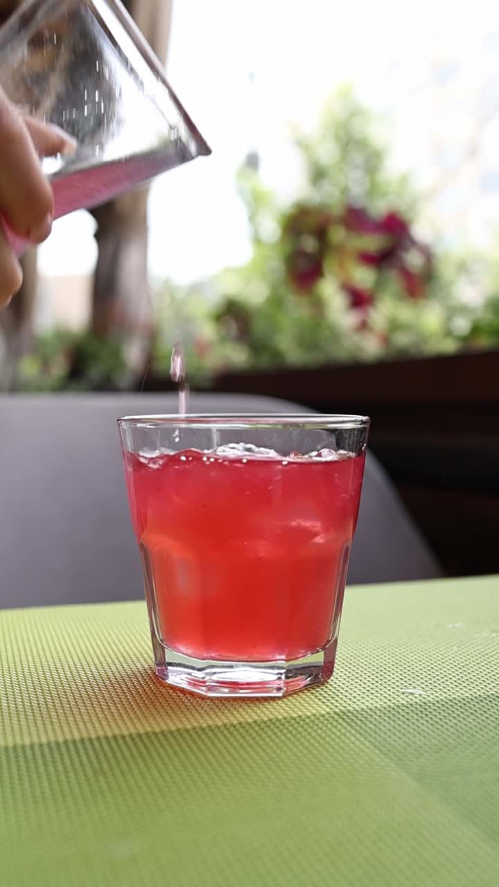 Versare una bevanda rosa