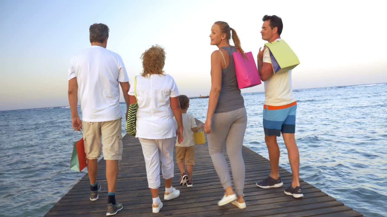 Big family with shopping bags on pier in the sea