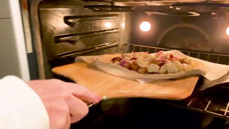 homemade pizza going into an oven to be cooked