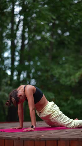 mujer practicando yoga en un entorno forestal