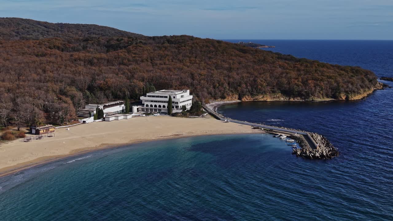 Serene ocean view with a beach and coastal forest in autumn colors