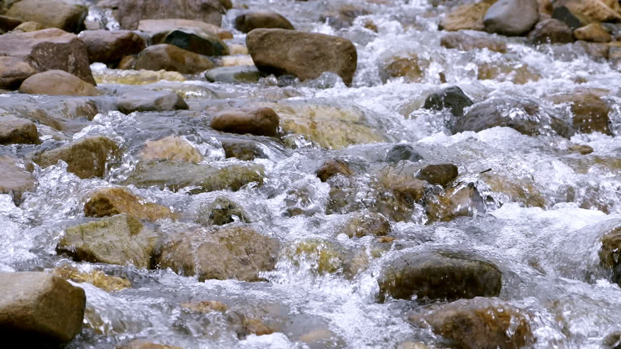 Ruscello limpido che scorre tra massi di pietra. Fiume copioso che scorre al rallentatore.