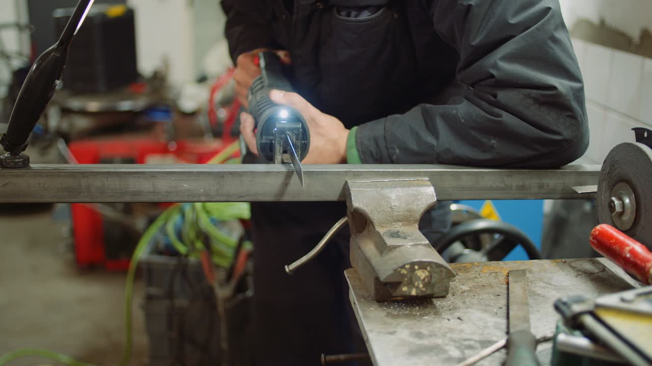 trabajador de la industria de piezas metálicas con sierra eléctrica