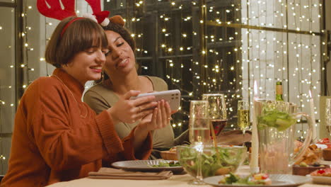 Dos-Mujeres-Divirtiéndose-En-La-Cena-De-Navidad