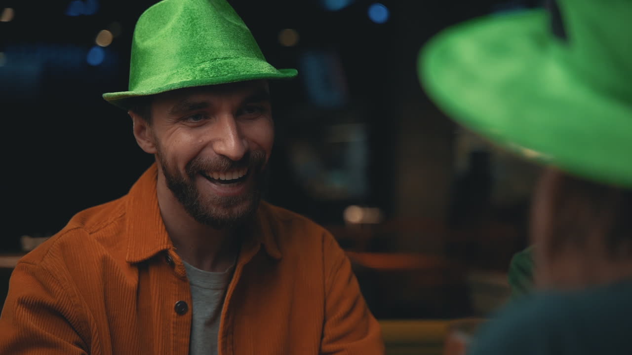 retrato de un hombre feliz con sombrero irlandés hablando con amigos en un pub