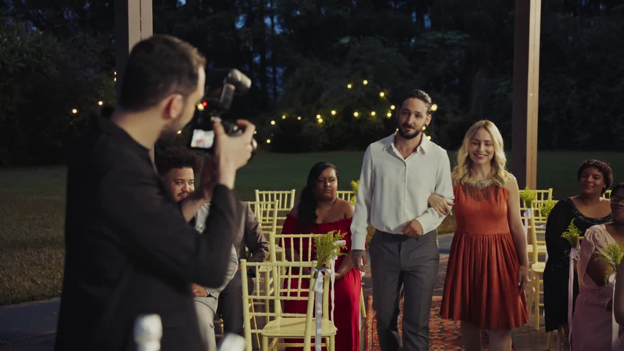 Photographer capturing moments at an outdoor evening wedding ceremony