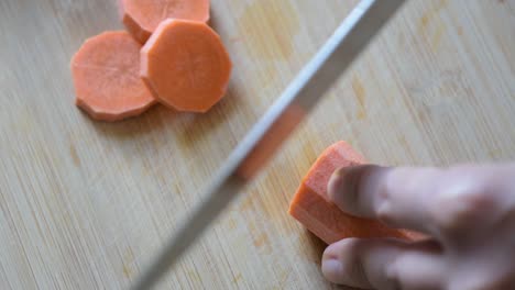 Primer-Plano-De-La-Vista-Superior-De-La-Mano-De-La-Mujer-Cortando-Una-Zanahoria