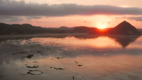 The-dry-reef-of-Kuta-Lombok-during-sunrise,-with-local-people-looking-for-food-and-seashells