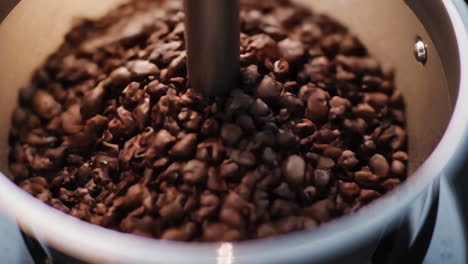 close-up of coffee beans being ground or roasted in a machine