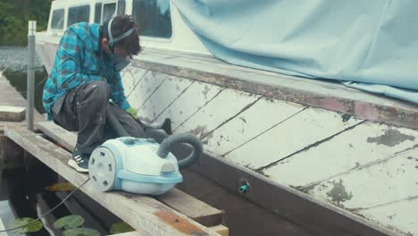 a carpenter hoovering out seams of wooden boat