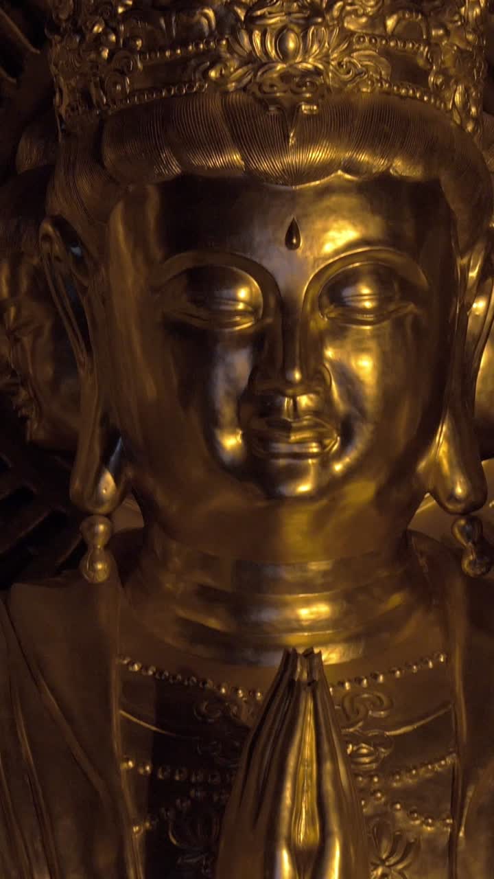 Primo piano di una statua dorata del Buddha con le mani nel mudra della meditazione