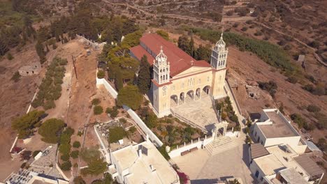 Panorámica-Toma-Aérea-De-Una-Hermosa-Iglesia-En-El-Pueblo-De-La-Isla-De-Lefkes-Grecia