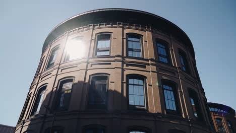 the sun's rays are reflected in the windows of the red brick building. modern urban architecture