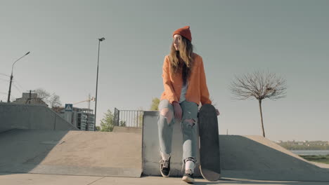 chica patinadora esperando a alguien sentado en un parque de patinaje