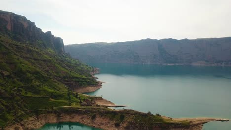 Paisaje-Escénico-Del-Lago-De-La-Presa-En-La-Temporada-De-Primavera-Acantilado-De-Roca-Prado-De-Pasto-Verde-Cubierto-En-Un-Clima-Nublado-En-Irán-Dezful-El-Paisaje-De-La-Colina-De-La-Montaña-Mar-Viaje-De-Aventura-Marina-Al-Océano-Verde-Costero