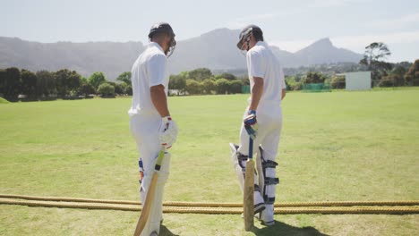 cricket players doing a check on a pitch