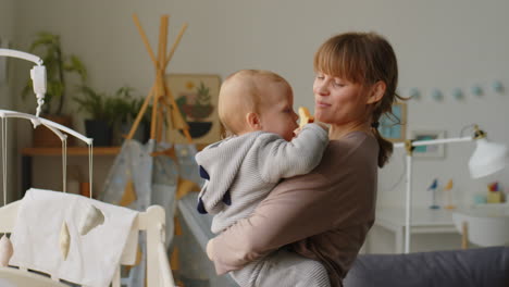 Cheerful Mother Bonding with Baby in Kids Room