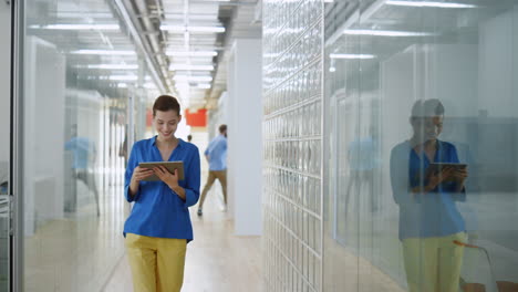 creative man talking phone in glass wall office. business woman looking tablet.