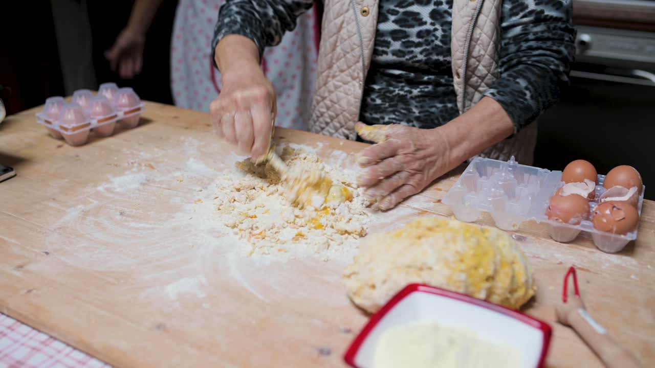 mujer de la cosecha preparando la masa en la mesa en la cocina
