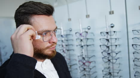 patient in optics store. male patient with new eyeglasses in store