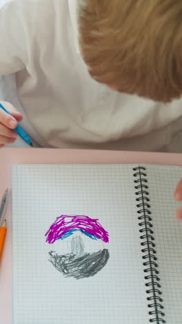 elder girl plays with eraser and pins while toddler boy draws at small table in classroom upper view. sister spends time with little brother at home