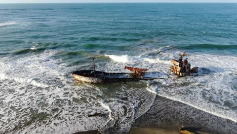 costa rica beach drone view showing sea, shore and a stranded ship on a sunny day over the atlantic ocean in the caribbean