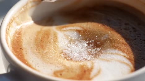 close-up of a cup of cappuccino with sugar