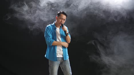 man singing on stage with smoke