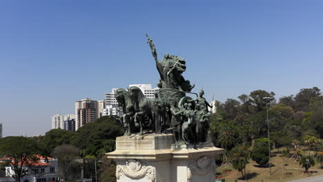 drone flying around the independence monument in the independence park with the independence museum displayed in the background