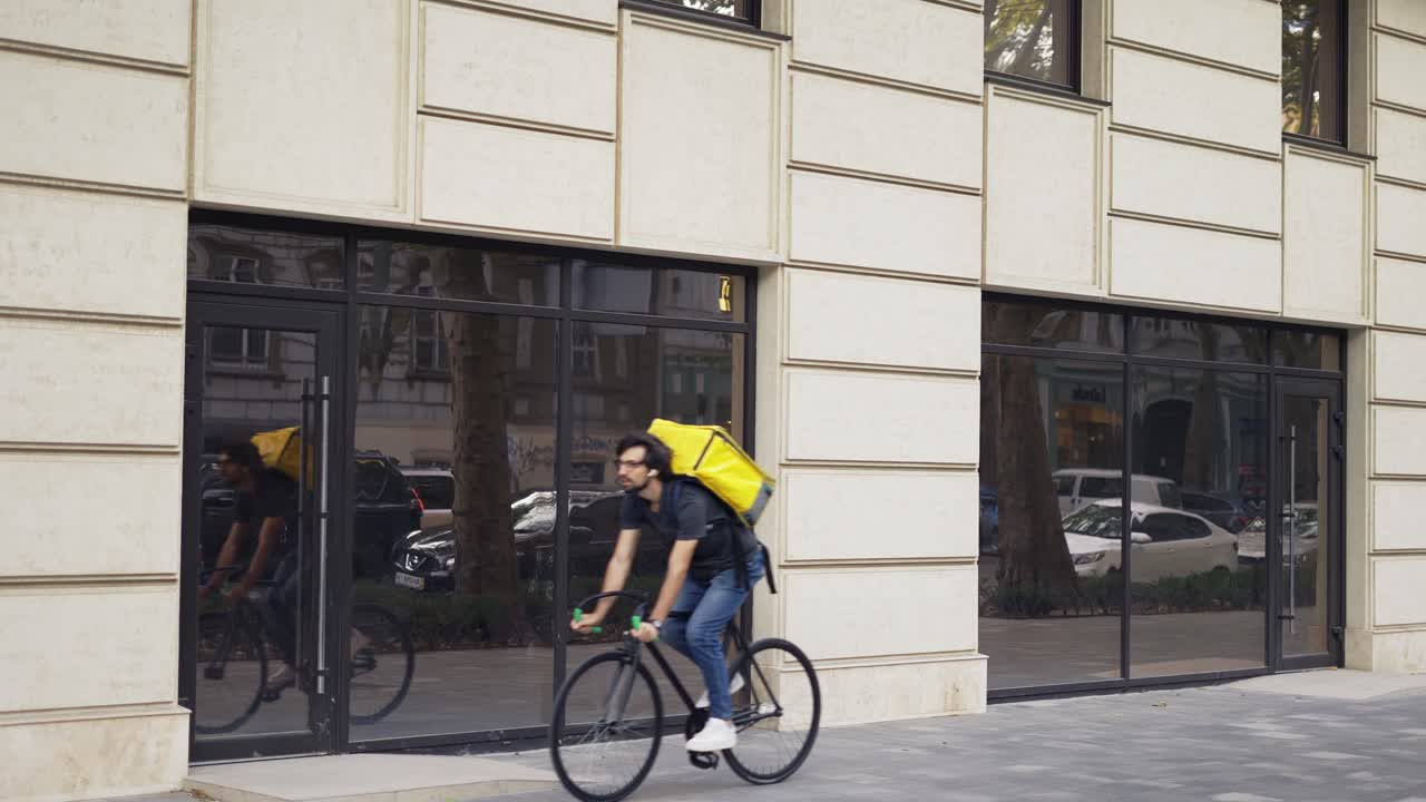 Courier on bike with thermal backpack, food delivery, slow motion