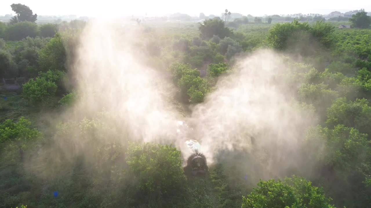 Tractor spraying pesticide drone aerial view, pesticides or insecticide spray on lettuce or iceberg field. Pesticides and insecticides on agricultural field in Spain