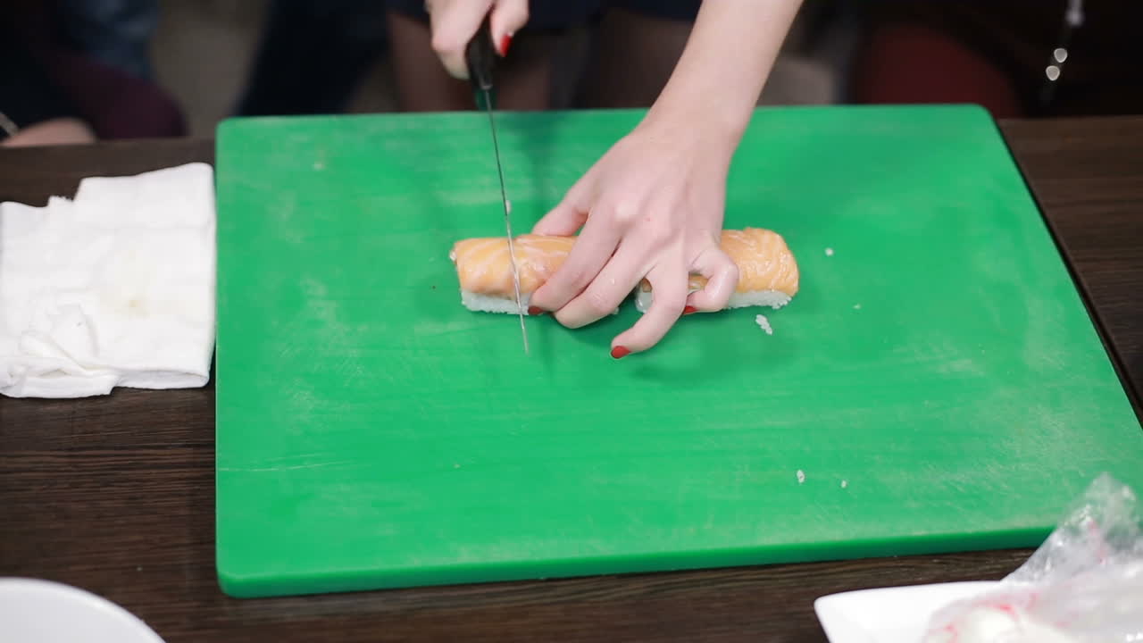 Process Of Making Sushi And Rolls. Cook woman making japanese sushi rolls in kitchen