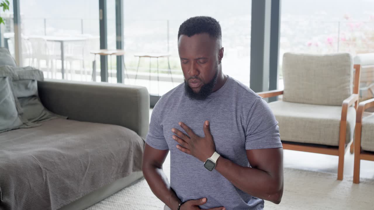 Adult African American man in tee settling on yoga mat at home, starting breathwork, calming mind