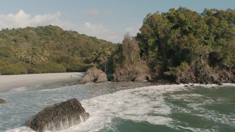 beautiful cinematic drone aerial of a cliff and the shore of the beach in national park, costa rica