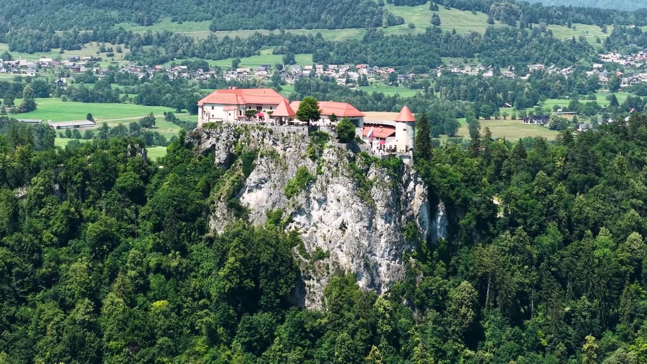 Ripresa con drone del Castello di Bled, punto di riferimento sulla scogliera e paesaggio in una soleggiata giornata estiva.