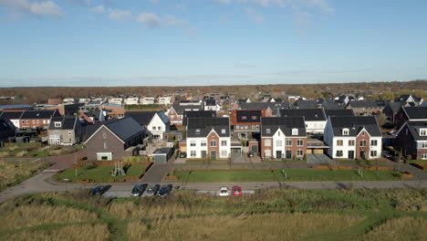 Aerial-dolly-of-modern-suburban-neighborhood-with-rooftops-filled-with-solar-panels