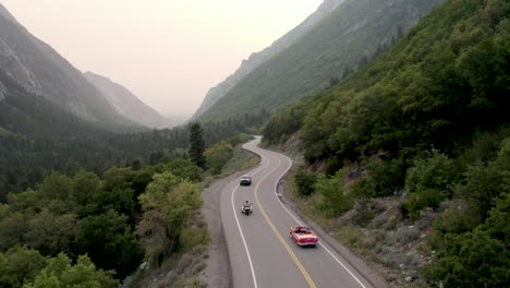 red convertible car driving on breathtaking scenic road in big cottonwood canyon, utah - aerial