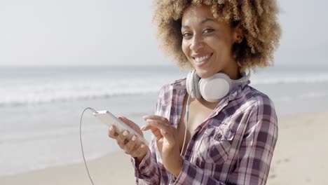 chica en la playa escuchando música