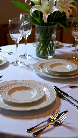elegant dining table setting with white lilies and dinnerware