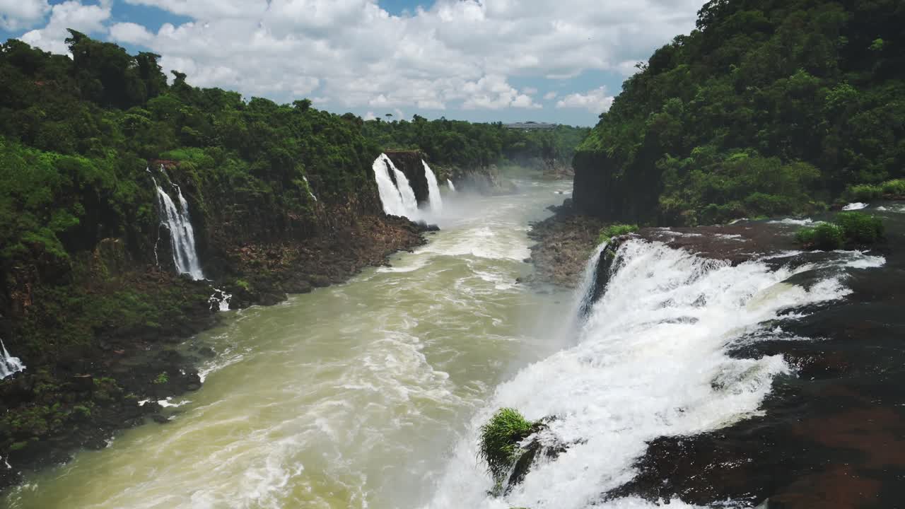 mirando hacia abajo larga extensión de hermoso valle de cascadas, cámara lenta ríos fuertes en el soleado brasil, corrientes ásperas de caídas de aguas en grandes arroyos de piscina en las cataratas de iguazu, américa del sur