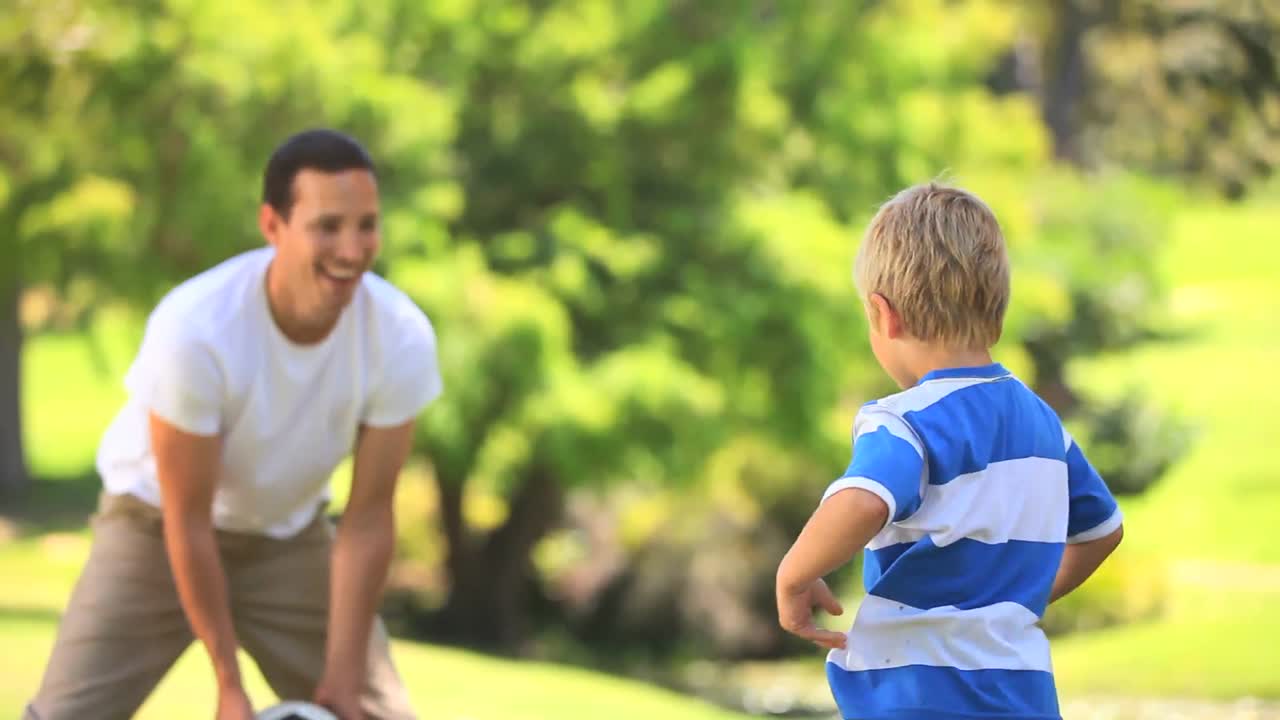 niño y su padre jugando con una pelota