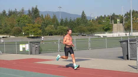 fitness man with muscular body running at the outdoor sports stadium