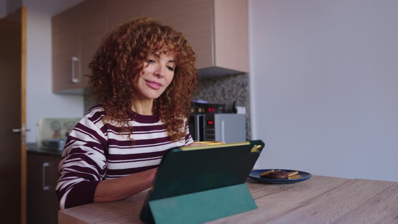 Woman using tablet for video call at home