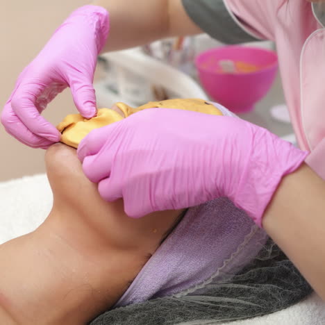 collagen face mask. beautiful young girl receiving facial cleansing procedure at a cosmetologist. facial skin treatment