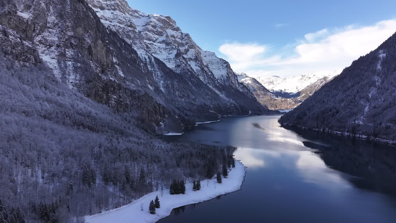 Snowy klöntalersee in glarus, switzerland, surrounded by wintery mountains, aerial view